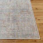 Corner detail of Darling Olive rug highlighting woven edges and pattern against wood plank flooring