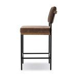 Side profile highlighting slim black metal legs and padded brown fabric seat and backrest