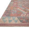 Close-up angled view showing the textured polyester pile and woven edge of the Malik Berry / Multi Rug