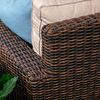 Side close-up of tightly woven cognac resin wicker armrest wrapped around frame with beige cushions