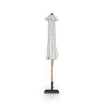 Collapsed Baska umbrella with cream canopy gathered around teak pole