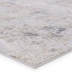 Close-up of the rug's textured surface showing tonal variations in light gray with bronze and gold accents