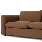 Close view of cushion edges and corner of sofa arm with rounded upholstery