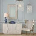 Two Glen Arbor pendants of different sizes styled above white cabinet with blue lamp and chair