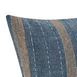 Close-up of blue patchwork fabric showing textured stitching and rust stripe accents