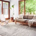 Wynter rug in a bright living room next to a chair and sofa, showing its scale in a modern natural decor setting