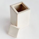 Top-down view of open jar with exposed interior and lid positioned on table nearby