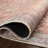Close-up of rug edge curled up revealing tightly woven underside and layered construction