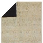 Corner flipped to show the black backing fabric of the rug