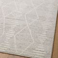 Close-up of rug surface on wood floor emphasizing textured linear and diamond pattern