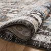 Partially rolled charcoal multi traditional rug showing woven texture and edge binding