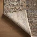 Rug corner flipped to reveal the woven back side with subtle pattern outlines