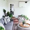 Rug used in outdoor living space styled with grey wicker seating and plants against white wall