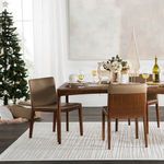 Rug under dining room table with holiday decor and Christmas tree in bright room with white walls