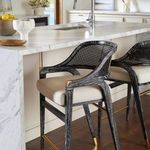 Close-up side view of two stools with beige seat cushions at marble kitchen island