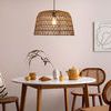 Sable Paper Rope Pendant Light in dining room setting above round table with chairs and wall art