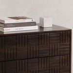 Styled living room side view with nightstand topped with stacked books and marble decor