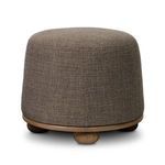 Rear angled view of ottoman showing full rounded shape, wooden bun feet, and fabric upholstery seam
