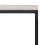 Close-up of light stone bench top texture and black frame corner showing smooth edges