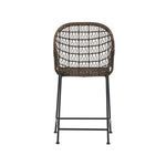 Side angle showing woven wicker armrest and part of black iron legs