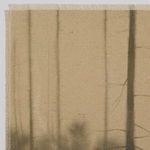 Close-up of raw edge of canvas fabric with muted tree silhouettes and texture