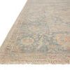 angled close-up of rug corner highlighting fringe and texture in soft blue and beige shades