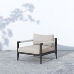 Sherwood chair shown outdoors on stone patio against white wall with shadows
