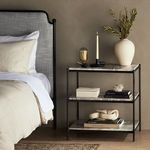 Another styled room view showing nightstand with decorative items beside bed
