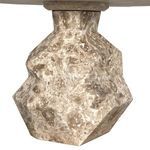 Underneath view focused on rough textured geometric marble base connecting to the smooth table top