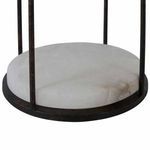 Close-up of round natural alabaster base with black metal frame around edge