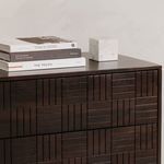 Close-up of dresser corner with stack of books and marble cube sculpture on top