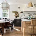 Black Lewis Windsor Chair paired at dining table in bright kitchen with wood floors and marble accents