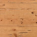 Extreme close-up of waxed pine wood planks showing nail holes and natural wood markings on tabletop