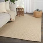 Rug styled in living room setting next to gray sofa, wicker side table on hardwood floor