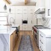 Runner rug displayed in bright kitchen with wood beams, white cabinets, and marble counters