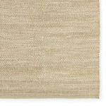 Close-up of the rug edge and the woven texture in beige and gray fibers