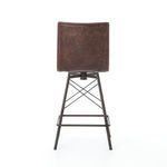 Rear view of bar stool’s square distressed leather back and iron base with footrest