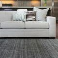 Close-up low angle showing Barkley Charcoal Rug under front of sofa with decorative pillows