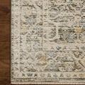Close view of rug corner highlighting detailed floral pattern and fringe on hardwood floor