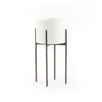 Tall outdoor planter with a smooth white cylindrical pot on a slender, textured dark metal stand