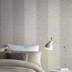 Vertical installation of Atelier Stripe Wallpaper shown in a bedroom setting with soft cushions and a white-gold desk lamp