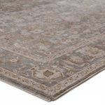 Close-up of rug corner showing low pile texture and detailed gray cream floral border