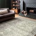 Rosette rug in room setting with dark gray brick fireplace, wooden furniture, and couch with throw pillow
