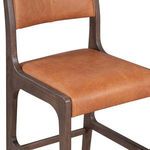 Close-up of seat cushion and wood frame corner emphasizing smooth leather texture