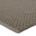 Close-up corner view showing thick braided texture and finished edging of gray woven rug