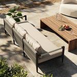 Outdoor patio scene with Sherwood sofa beside wooden coffee table and natural stone flooring