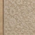 Corner placement of the Prudence Clay Ivory Rug on light wood flooring highlighting the floral pattern and woven border de...