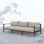 Sherwood sofa positioned on textured stone floor with natural light highlighting fabric and frame