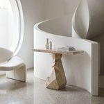 Tilden Console styled in modern white interior with curved staircase, decorative objects on tabletop, and sculptural chair...