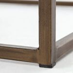 Close detail of aged brass base joint and floor protector under end table leg